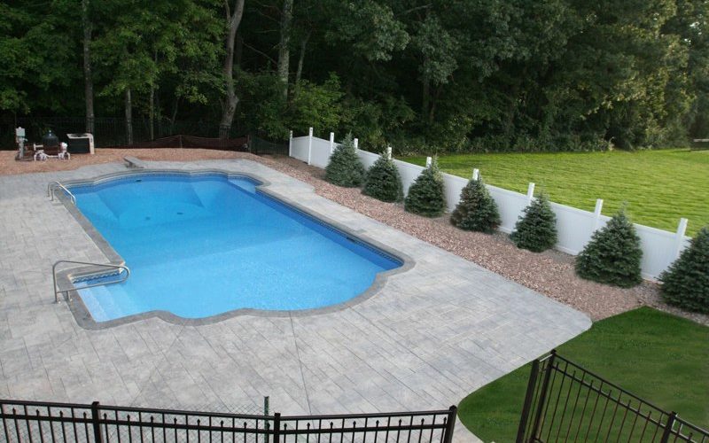 This is a photo of a roman in ground pool in Kinderhook, NY with custom pavers, diving board and steps.