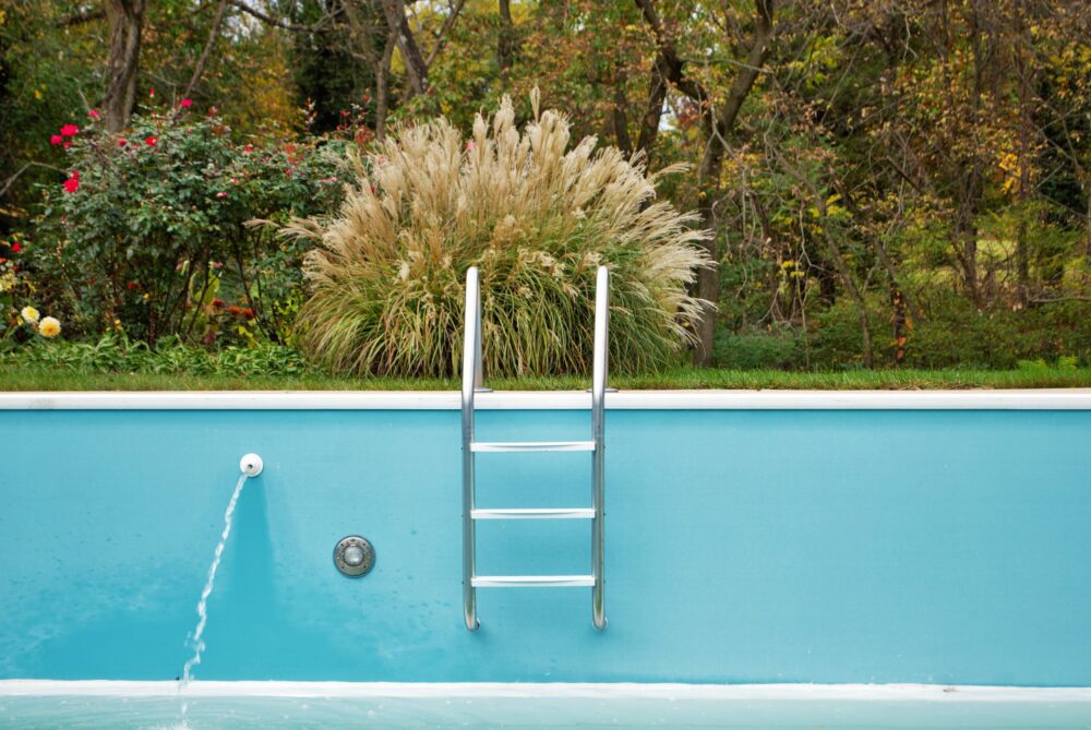 backyard swimming pool with ladder emptied out shutting down for winter